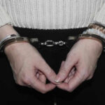 Espionage Act Shocker: Source Named, Arrest Follows Person in handcuffs wearing a sweater