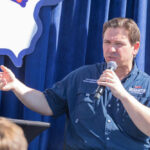 Supreme Court Drama: DeSantis Targets Dream Job Person speaking into microphone during public event