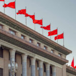 Facade of a government building adorned with red flags