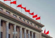 Facade of a government building adorned with red flags