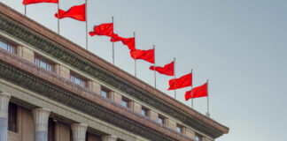 Facade of a government building adorned with red flags
