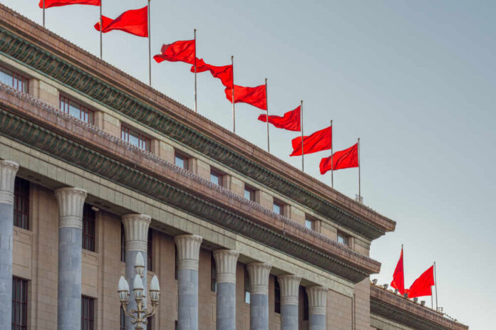 Facade of a government building adorned with red flags