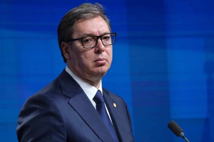 A serious-looking man in formal attire at a press conference