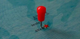 Red pin marking Guam on a blue map