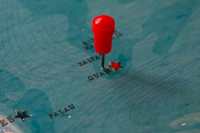 Red pin marking Guam on a blue map