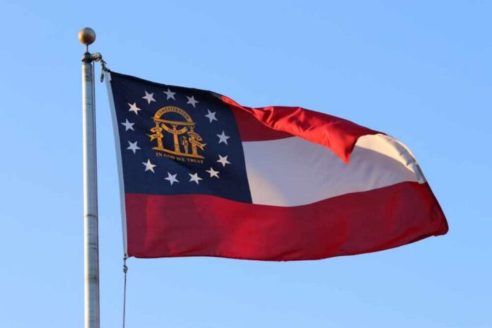 Georgia state flag waving against a clear blue sky