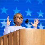A female speaker passionately addressing an audience from a podium