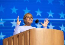 A female speaker passionately addressing an audience from a podium