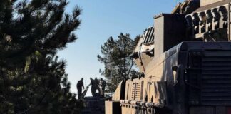 Silhouette of soldiers near a military vehicle in a wooded area