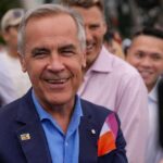 Carney’s Bold Move: Diversifying From U.S. Dependence A smiling man in a blue suit surrounded by a diverse crowd at an outdoor event