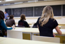 Students seated in a classroom listening to a teacher