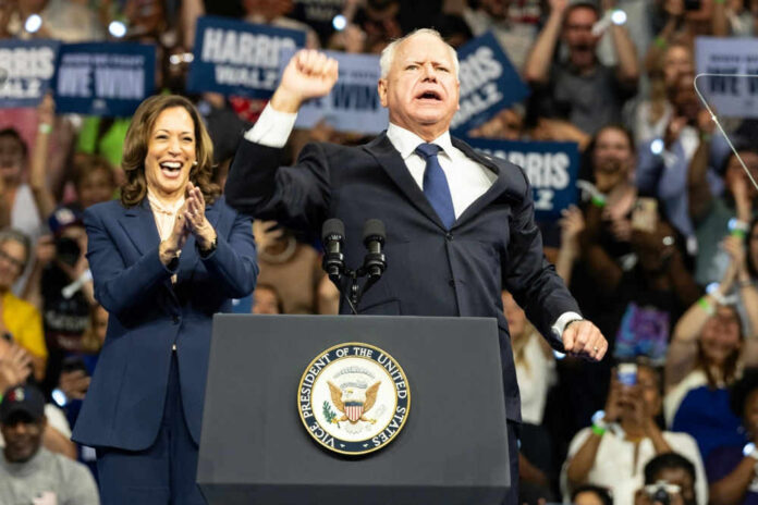 Kamala Harris and unidentified man at podium, cheering crowd.