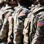 Covert Raid LEAKED—Soldier Profits $400K Soldiers in camouflage with American flag patches standing