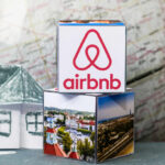 Airbnb logo on stack of cubes with map background