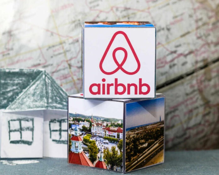 Airbnb logo on stack of cubes with map background