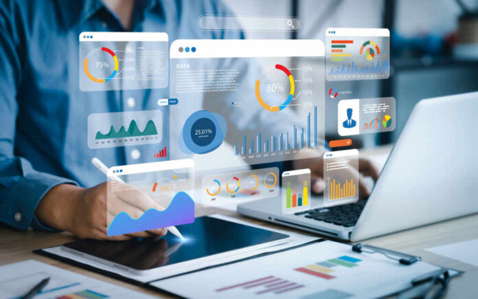 Person using tablet and laptop with data graphics