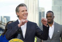 Is Newsom’s Diaper Program a Budget Buster? Person speaking at podium with others in background