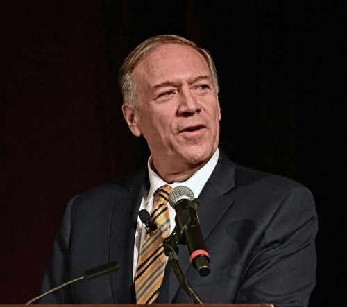Man speaking into a microphone on stage.