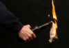 Person holding molotov cocktail with flame burning cloth