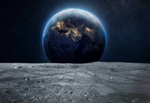 Earth rising above the moon’s barren surface in deep space