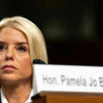 Woman sitting behind nameplate at conference or meeting