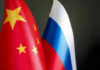 Russia-China Economic Power Play Unfolds Chinese and Russian flags on dark background