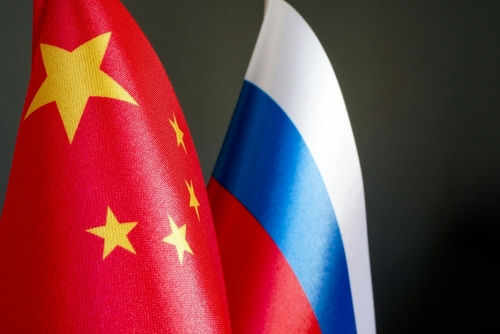 Chinese and Russian flags on dark background