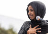 Trump DEMANDS Congresswoman Expelled From America Ilhan Omar speaking at a microphone during an event