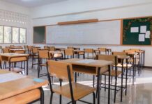 Massive NYC School Exodus Sparks Panic An empty classroom with wooden desks and a chalkboard