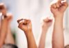 Police Zones Muzzle Newark Protest? Multiple raised fists in a show of solidarity during a protest