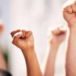 Police Zones Muzzle Newark Protest? Multiple raised fists in a show of solidarity during a protest
