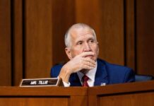 Senate Showdown: Tillis Challenges Trump’s Texas Strategy A politician sitting at a desk with a thoughtful expression during a hearing