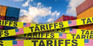 Yellow caution tape with the word 'TARIFFS' over a background of shipping containers