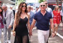 A couple walking hand in hand at a public event, surrounded by people