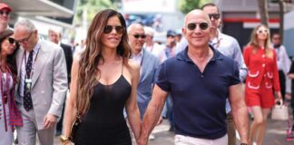 A couple walking hand in hand at a public event, surrounded by people