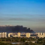 Shocking Escalation: Russia Targets Kyiv Civilian Zones A view of destroyed buildings with smoke rising in the background