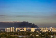 Shocking Escalation: Russia Targets Kyiv Civilian Zones A view of destroyed buildings with smoke rising in the background