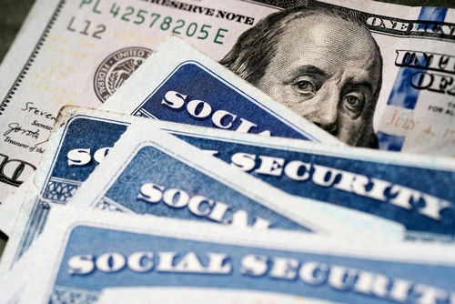 Social Security cards with one hundred dollar bill