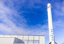 SpaceX Falcon 9 booster displayed outside industrial building