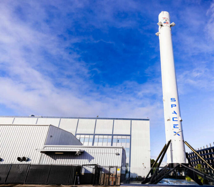 SpaceX Falcon 9 booster displayed outside industrial building