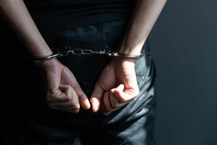 handcuffed-hands-of-a-prisoner2182647107jpg Person with hands cuffed behind back in handcuffs