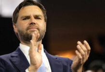 Man in suit clapping at an event