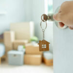 Hand turning door key with house-shaped keychain