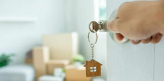 Hand turning door key with house-shaped keychain