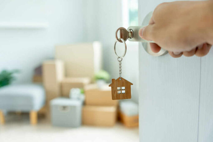 Hand turning door key with house-shaped keychain