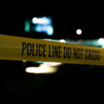 Texas Teen Couple’s Deadly Dating Trap Yellow police line tape at night with blurred city lights