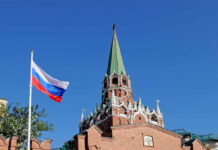 Fuel Chaos Exposes Putin’s ‘Superpower’ Myth Russian flag and Kremlin tower against a clear blue sky