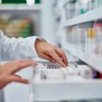 Pharmacist organizing medication on a shelf