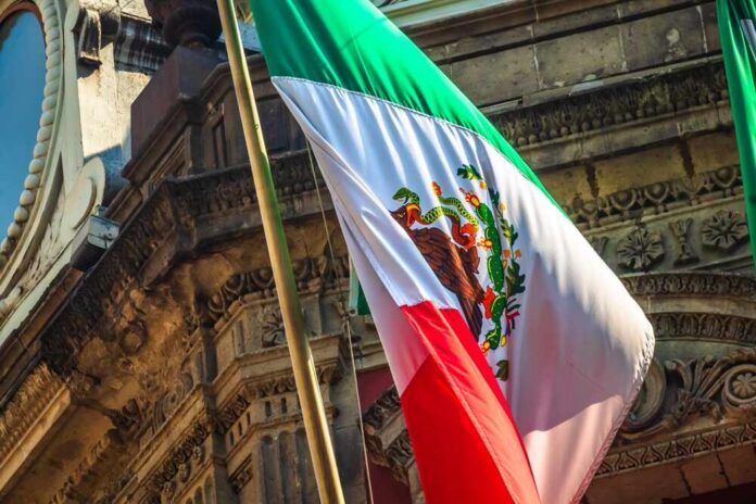 Mexican,Flag,On,Building,In,Mexico,City Person speaking at podium with Mexican flag nearby