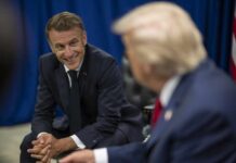Two political leaders engaged in a conversation, one smiling